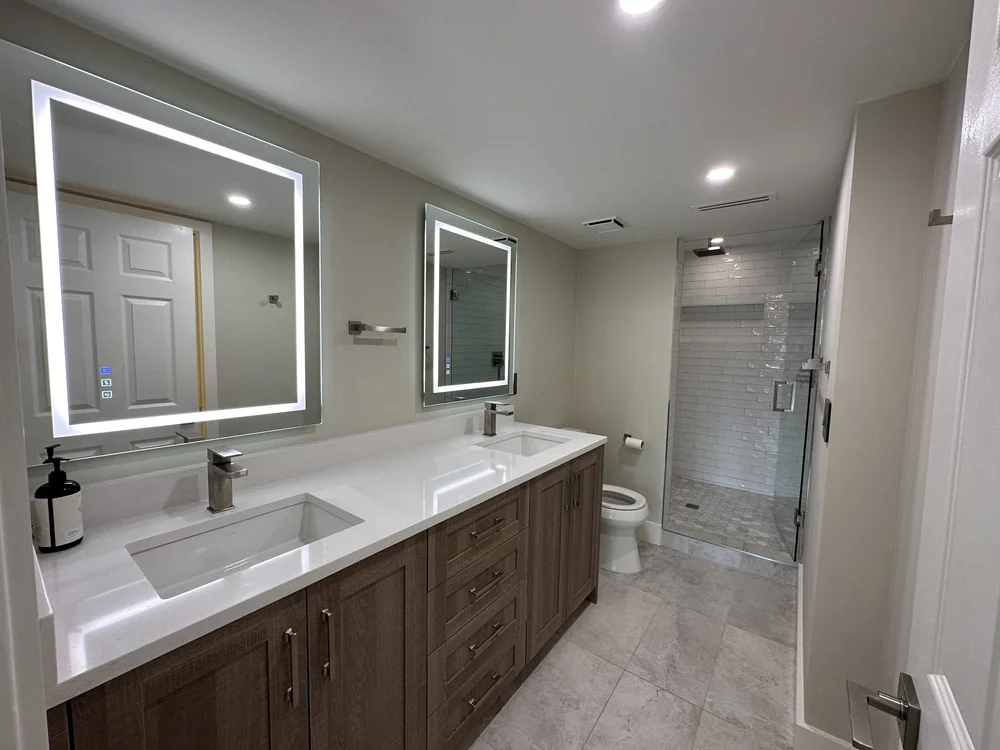 Finished bathroom remodel with double vanity and glass shower